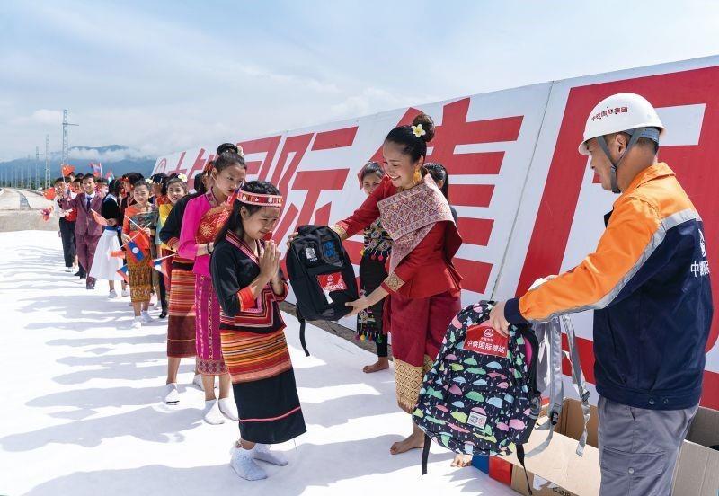 The staff of the project present handbags to the students.